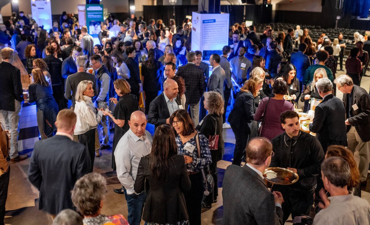 Crowded corporate reception under blue uplighting