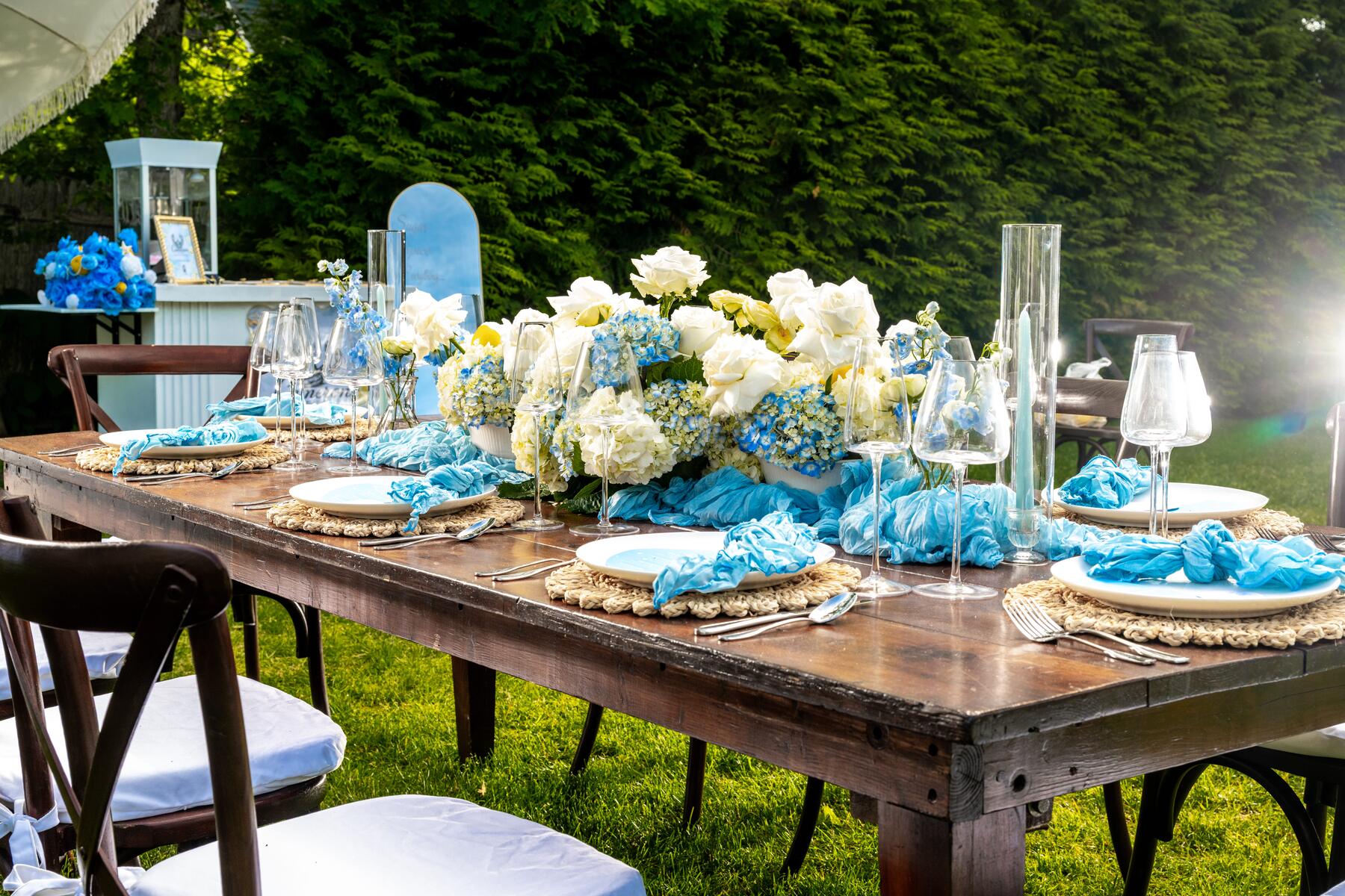 Garden table set with white roses, blue hydrangeas, and lemons