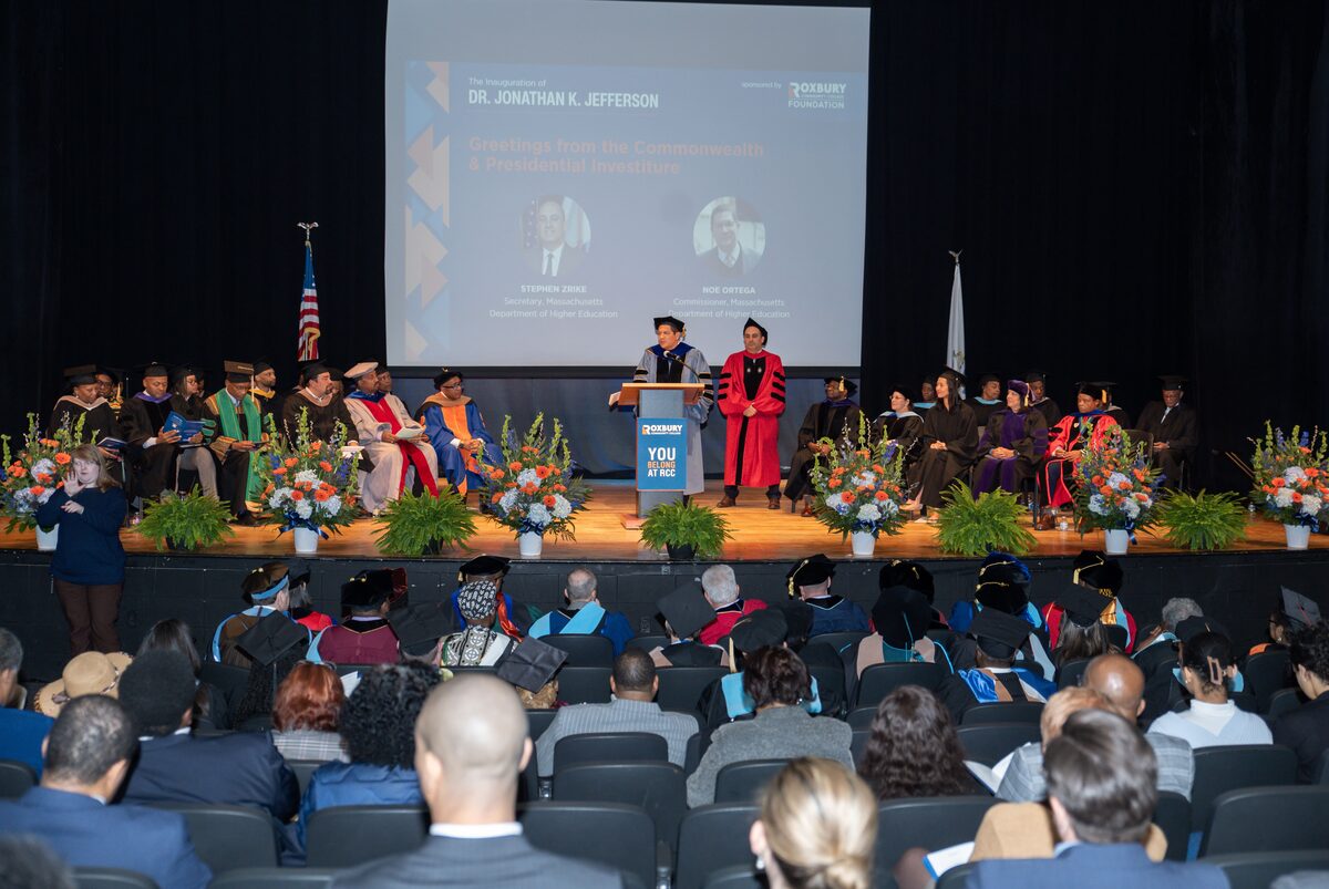 Stage with speakers and floral arrangements at an inauguration ceremony